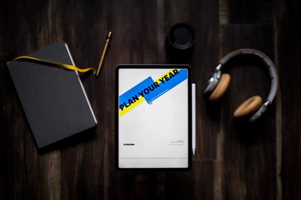 A diary, a tablet saying plan your year a pen and headphones.