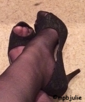 Black heels. I'm wearing heels and stockings. My feet are crossed at the ankle
