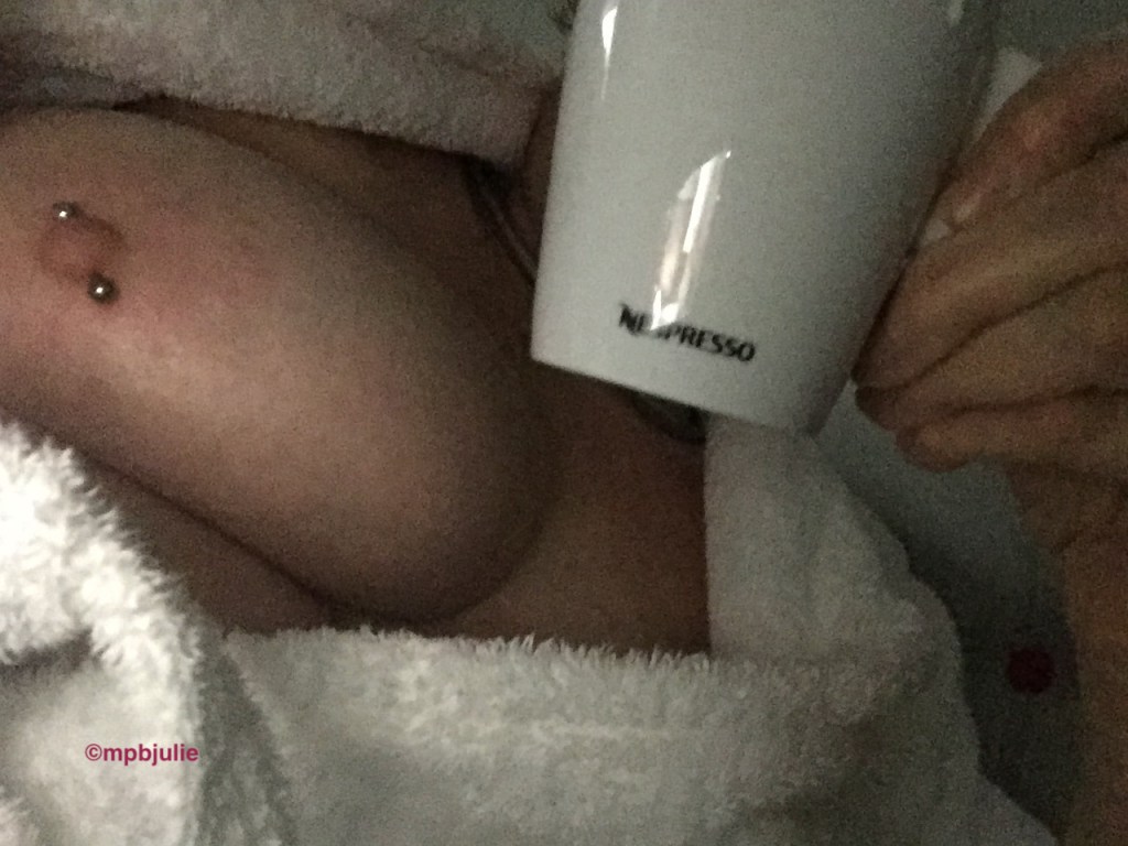 I am lying in bed wearing a towelling robe. All you can see is my hands cup and breast framed by the robe.