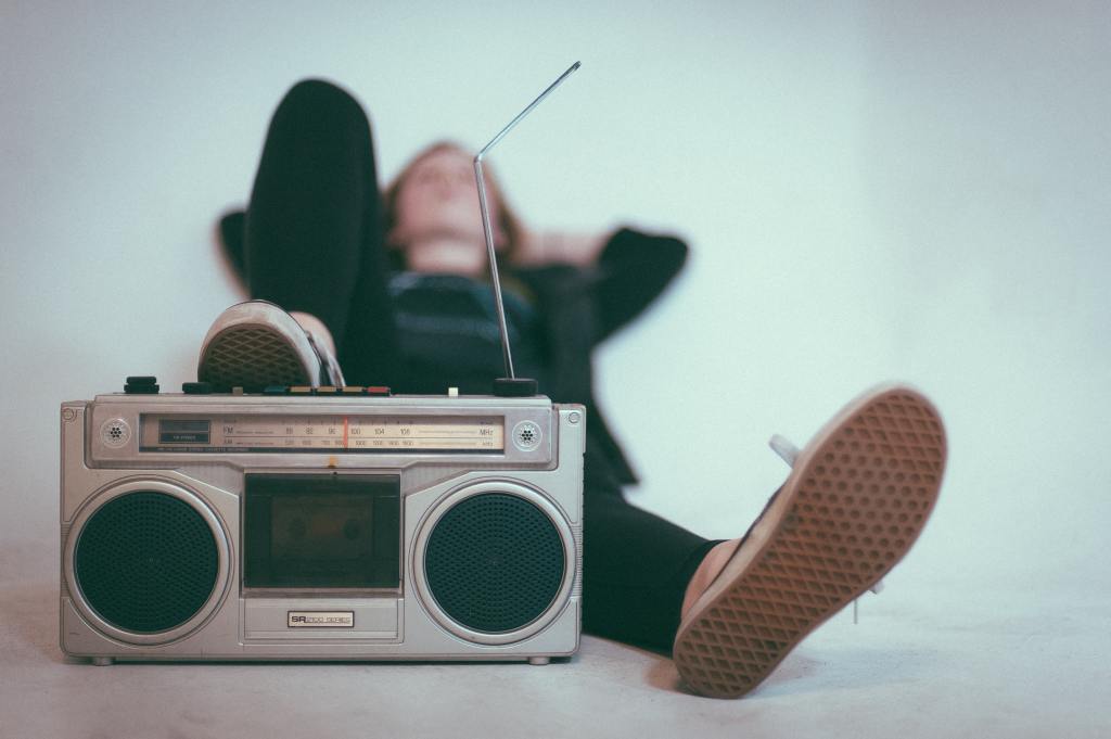 Someone lying back, their foot resting on a portable radio cassette player