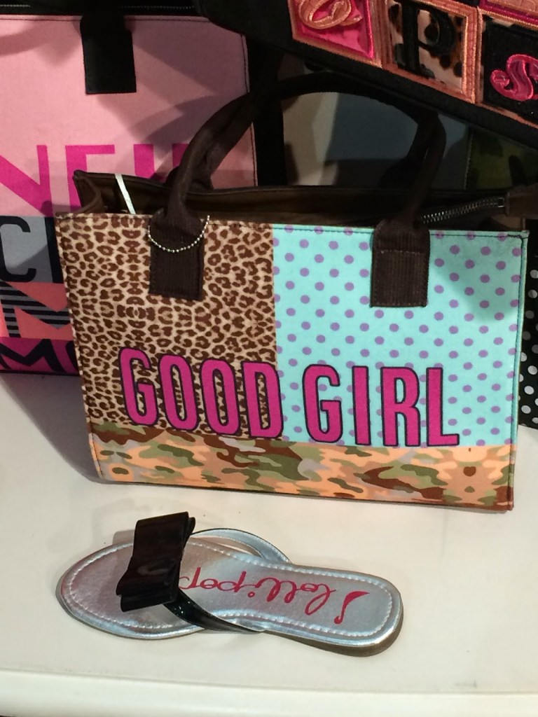 A bag. Multi coloured leopard print, blue background with pink spots and a swirly brown, green and brown. The words good girl are written in dark pink across.  
