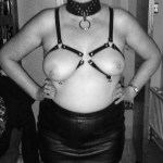 I am wearing a harness to shape my breasts, a posture collar and short leather skirt. I look very pleased with myself.