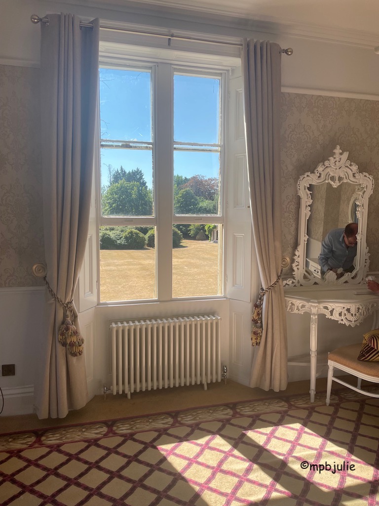 Window looking out to the grounds and view, dressing table to right of window.