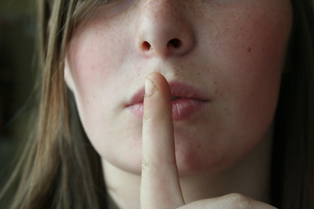 Woman with her finger in front of her lips