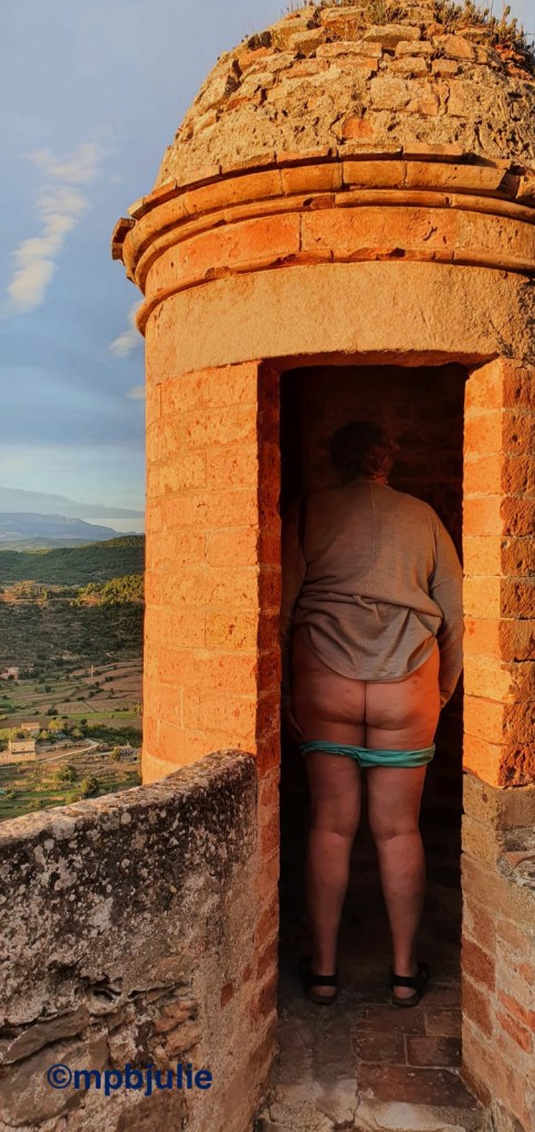 I'm standing in a lookout turret of a castle, showing my bum. Ypi can see my cardigan, knickers, bum, legs
and sandals.