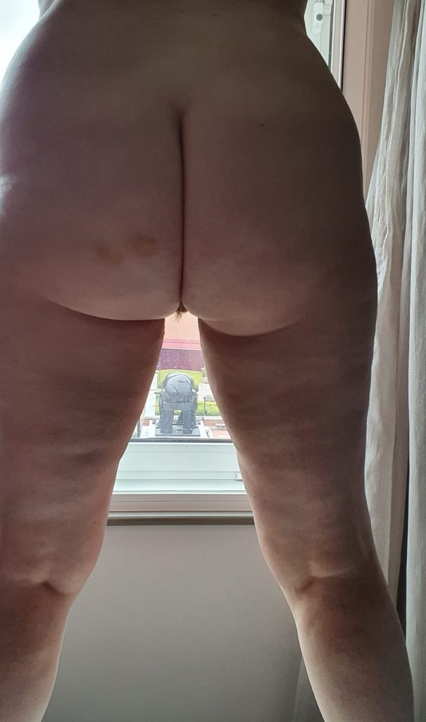 Me standing in front of the widow naked. You can mainly see my bottom. The other side of the window is a statue of a figure from the back. You can see his bottom too.